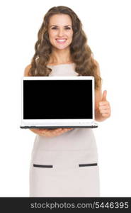 Happy young woman showing laptop blank screen showing thumbs up