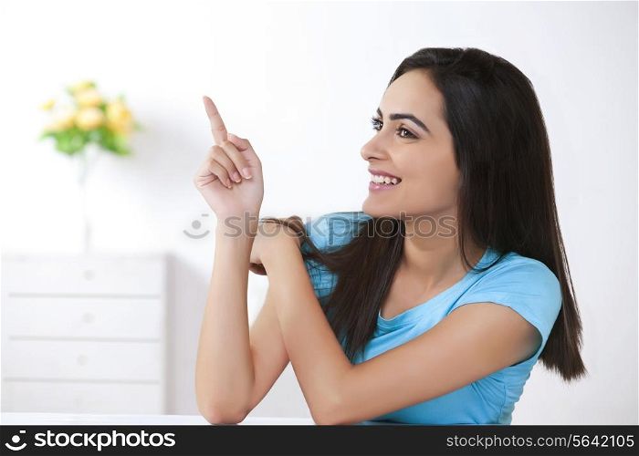 Happy young woman showing something at home