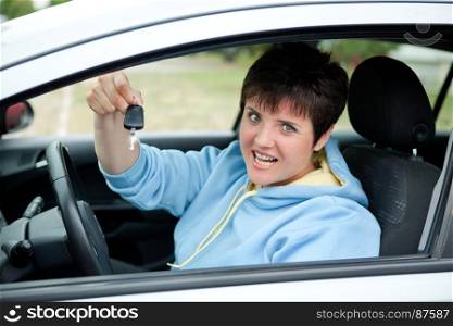 Happy Young Woman Showing the Key of Her New Car in her Hand in the Road