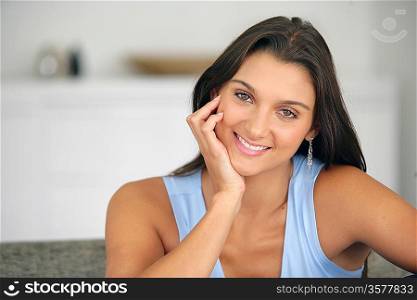 Happy young woman sitting at home