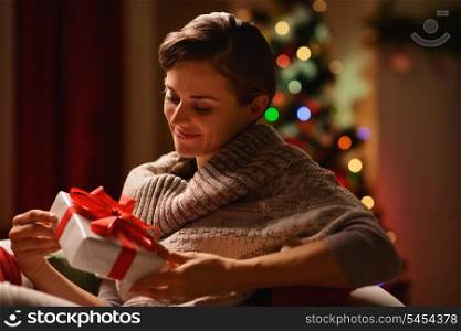 Happy young woman sitting chair with Christmas present box