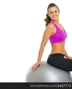 Happy young woman sitting on fitness ball