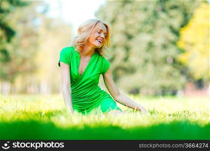 Happy young woman sitting on grass
