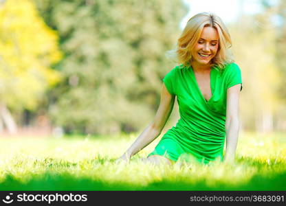 Happy young woman sitting on grass