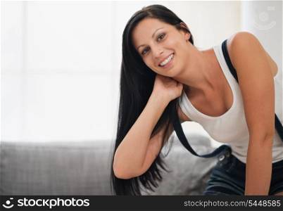Happy young woman sitting on sofa