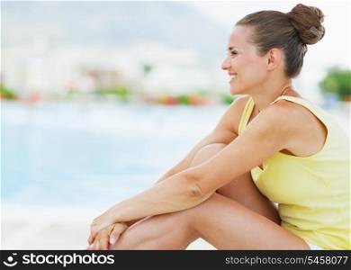 Happy young woman sitting on sunbed