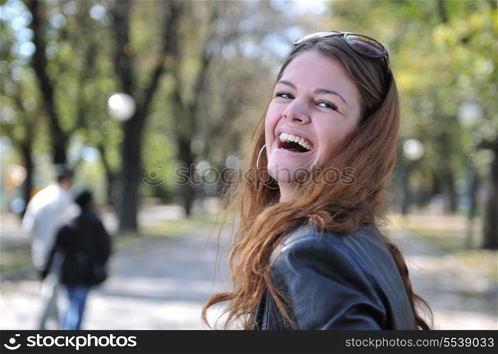 Happy young woman smiling outdoors in park