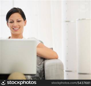 Happy young woman surfing net on laptop