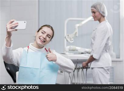 happy young woman taking selfie dentist