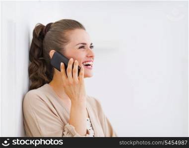 Happy young woman talking mobile phone and looking on copy space