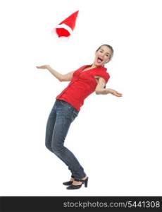 Happy young woman throwing Santa hat