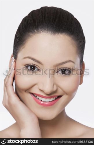 Happy young woman touching her face