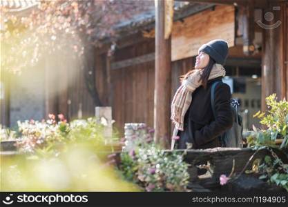 Happy young woman traveler traveling at the Square street in Lijiang Old Town, landmark and popular spot for tourists attractions in Lijiang, Yunnan, China. Asia travel concept