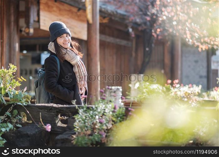 Happy young woman traveler traveling at the Square street in Lijiang Old Town, landmark and popular spot for tourists attractions in Lijiang, Yunnan, China. Asia travel concept