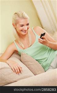 Happy young woman typing sms on mobile phone