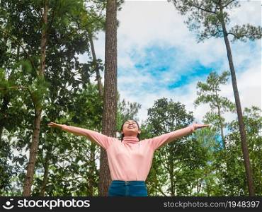 Happy young woman walking in the park and enjoying with nature in spring season.