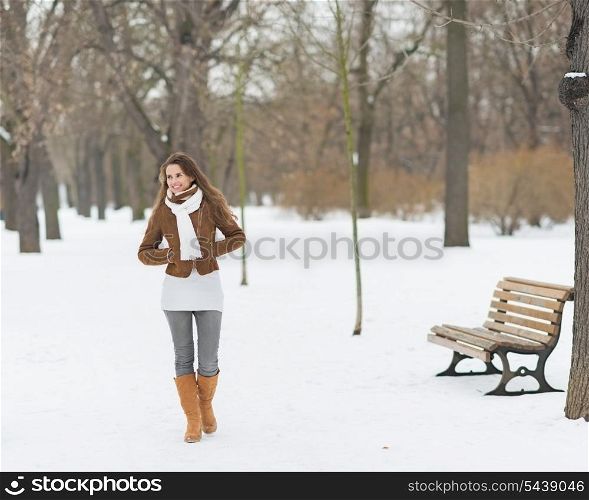Happy young woman walking in winter park