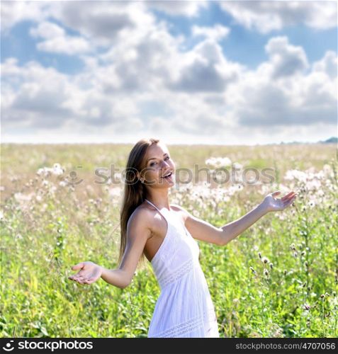 Happy young woman walks in summer field