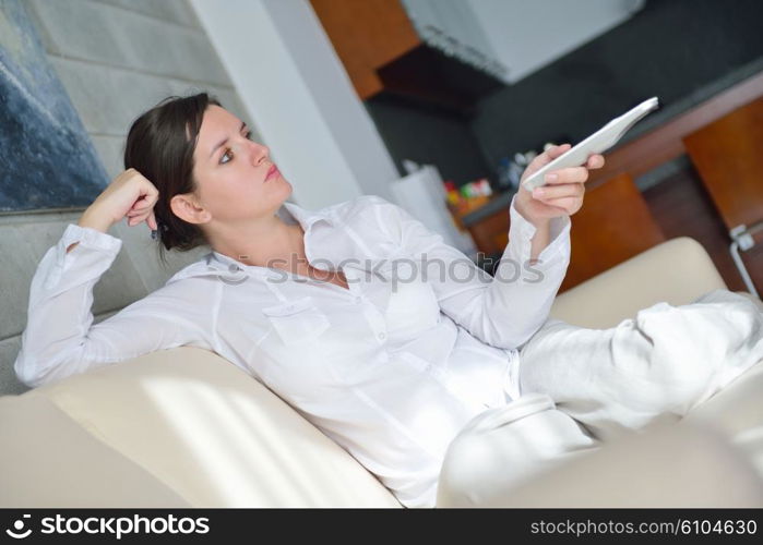 happy young woman watching tv at modern home livingroom