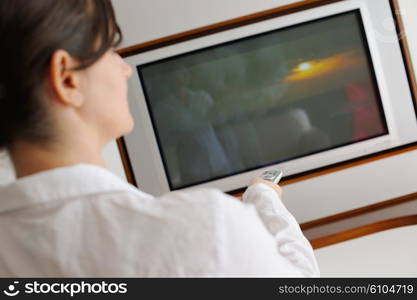 happy young woman watching tv at modern home livingroom