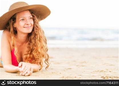 Happy young woman wearing bikini lying on tropical sand beach in summer for holiday travel vacation.. Happy young woman at beach in summer vacation.