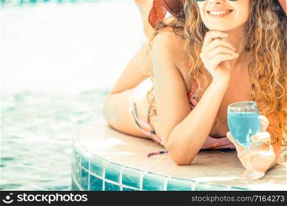 Happy young woman wearing swimsuit having good time at swimming pool in luxury resort. Summer travel holiday concept.. Happy young woman in swimsuit at swimming pool.