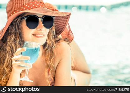 Happy young woman wearing swimsuit having good time at swimming pool in luxury resort. Summer travel holiday concept.. Happy young woman in swimsuit at swimming pool.