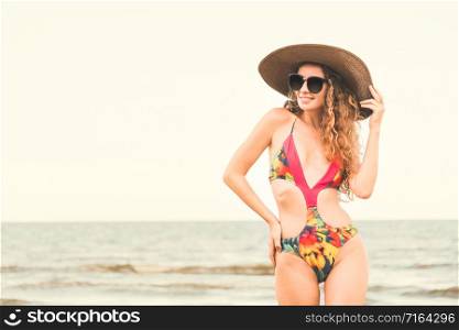 Happy young woman wearing swimsuit having good time at tropical beach in summer for holiday travel vacation.. Happy young woman at beach in summer vacation.