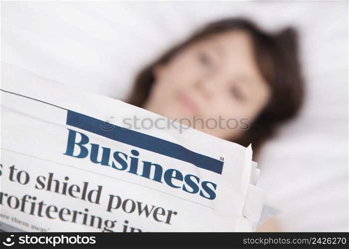 Happy young woman with a astonish expression reading a financial newspaper