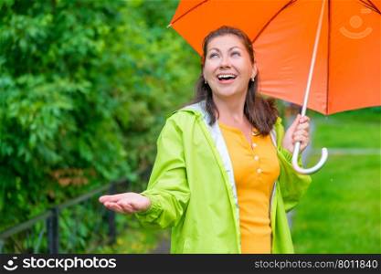 happy young woman with a bright umbrella waiting for the end rain