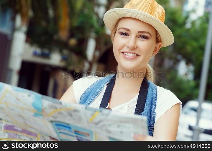 Happy young woman with a map. I like new cities