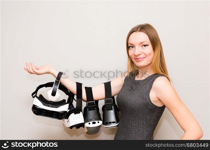 Happy young woman with a virtual reality headsets. Beautiful young girl hold the group of headsets virtual reality in her hand