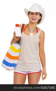 Happy young woman with beach bag showing sun screen creme