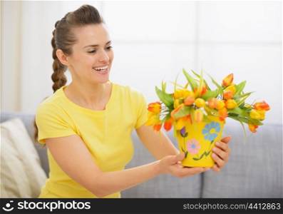 Happy young woman with bouquet of tulips in bucket