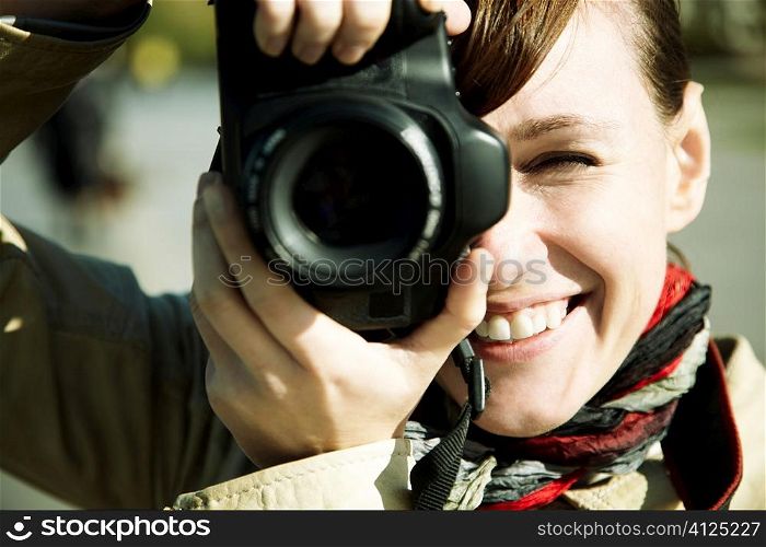 happy young woman with camera, toned, focus point on eye