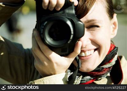 happy young woman with camera, toned, focus point on eye
