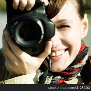 Happy young woman with camera, toned, focus point on eye