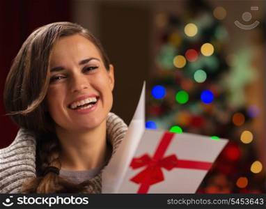Happy young woman with Christmas postcard