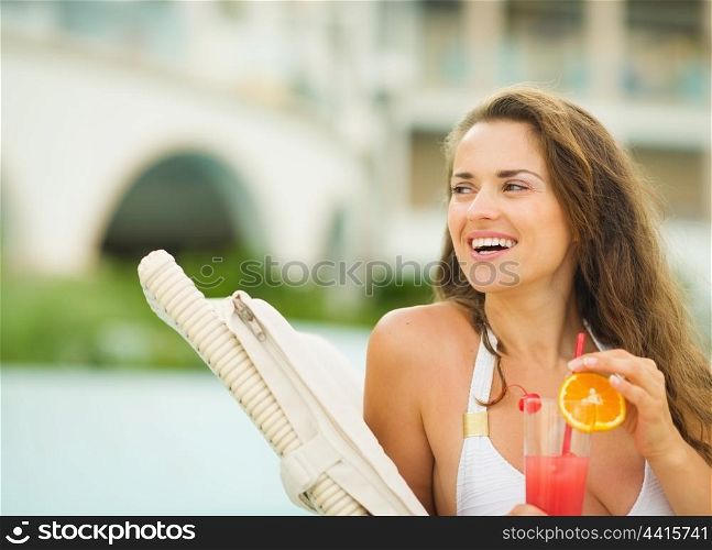 Happy young woman with cocktail looking on copy space