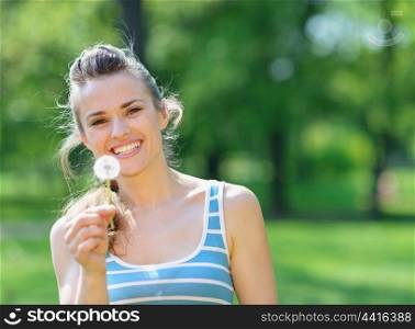 Happy young woman with dandelion