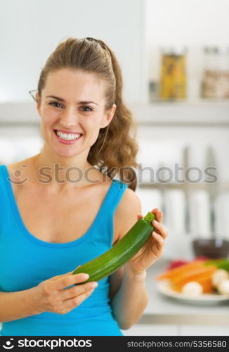 Happy young woman with fresh zucchini