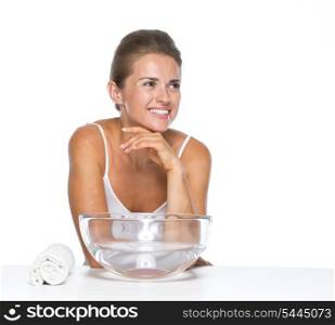 Happy young woman with glass bowl with water looking on copy space