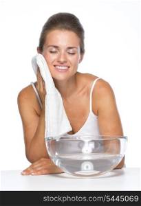 Happy young woman with glass bowl with water towel