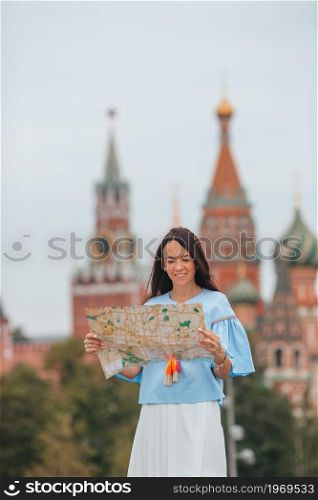 Happy young woman with map outdoors in Moscow city. Happy young urban woman in european city.