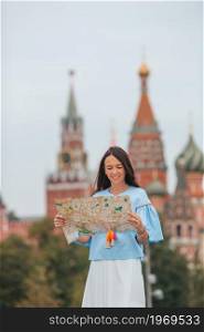 Happy young woman with map outdoors in Moscow city. Happy young urban woman in european city.