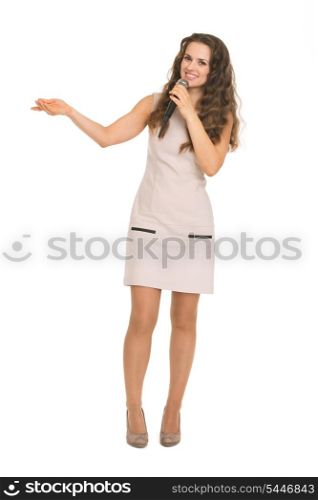 Happy young woman with microphone pointing on copy space
