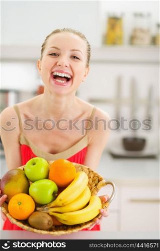 Happy young woman with plate of fruits