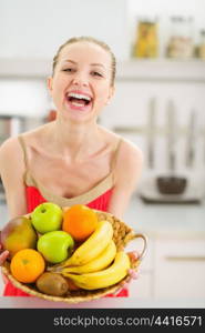 Happy young woman with plate of fruits