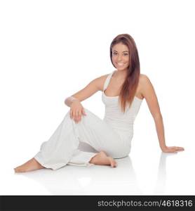 Happy young woman with white comfortable clothing sitting on the floor isolated