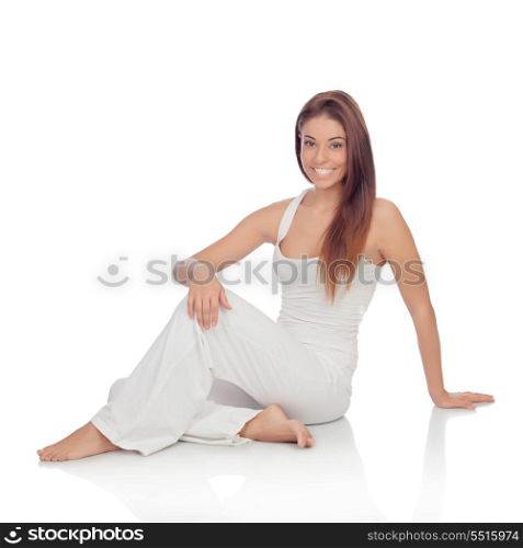 Happy young woman with white comfortable clothing sitting on the floor isolated
